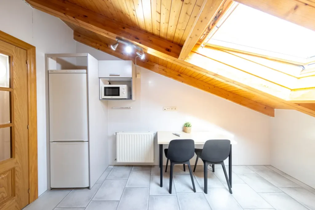 Cocina equipada con nevera, horno y office bajo la claraboya