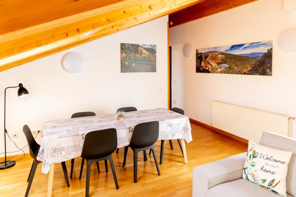 Zona de comedor con mesa y sillas bajo el techo abuhardillado
