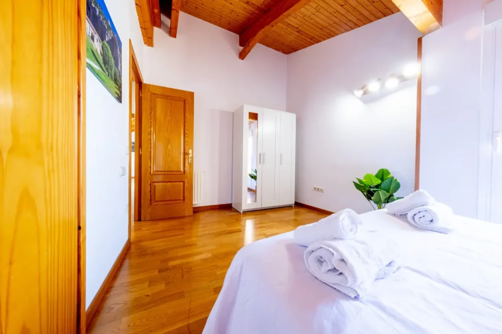 Dormitorio con armario y toallas preparadas sobre la cama