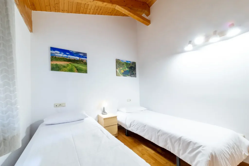 Habitación con dos camas gemelas y vigas de madera vistas