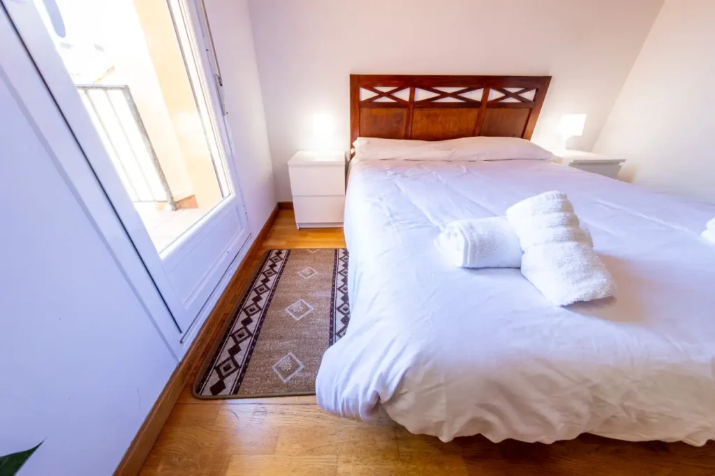 Cama de matrimonio bajo la claraboya con toallas dobladas