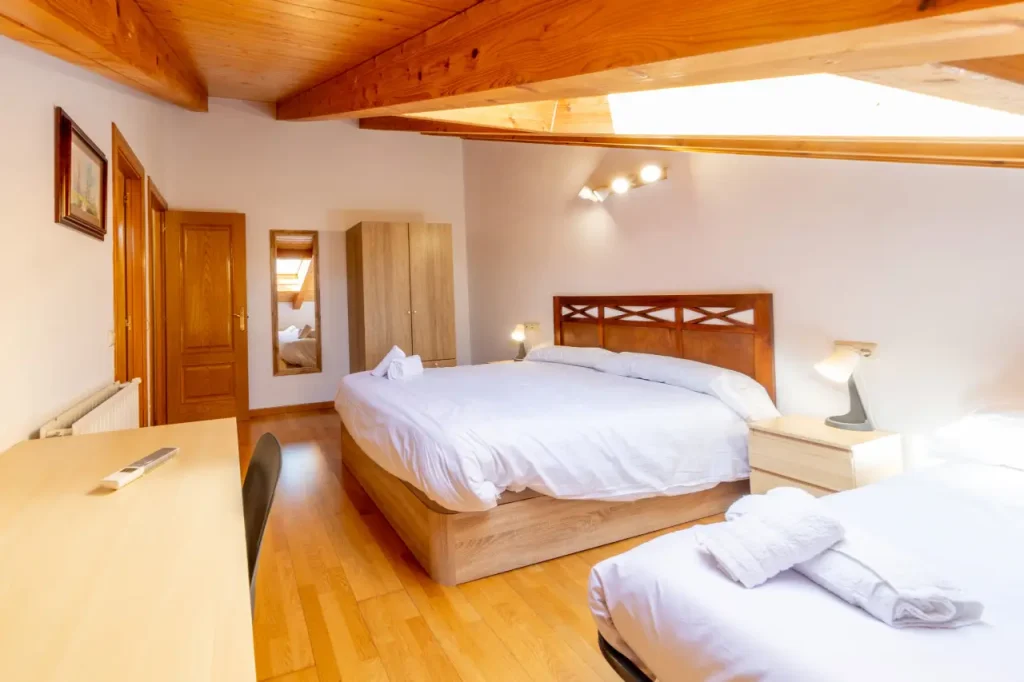 Dormitorio de matrimonio con espejo y toallas preparadas