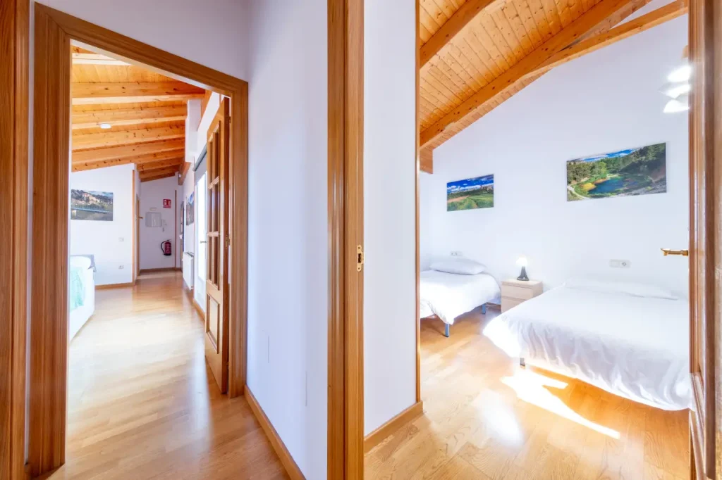 Pasillo de la vivienda con suelo de madera y puertas a las habitaciones