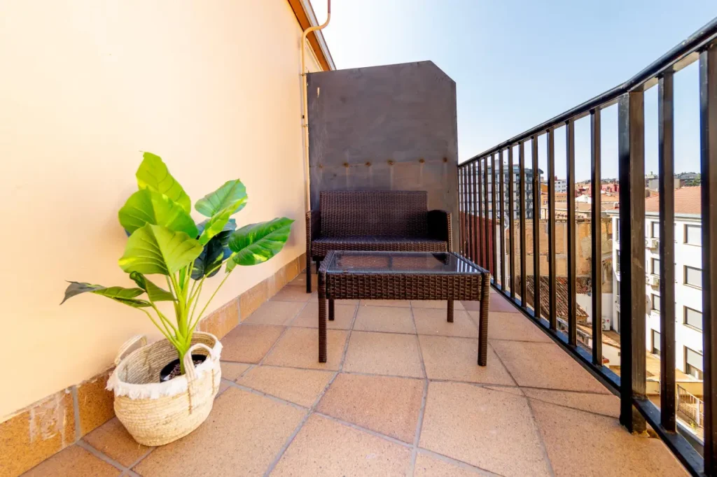 Terraza privada con mesa, sillas y vistas sobre los tejados